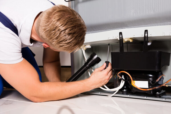 Appliance Repair Technician Checking Refrigerator in Chicago IL 60660